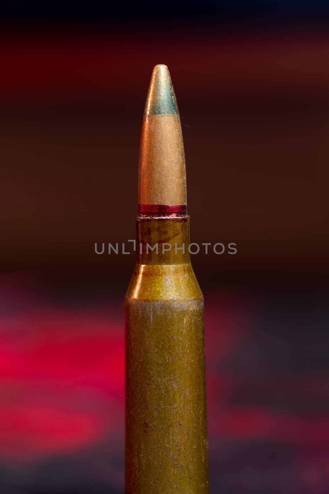 Rifle AK-47 ammo bullet close-up on blurred background. Armor piercing cartridge. by alexsdriver
