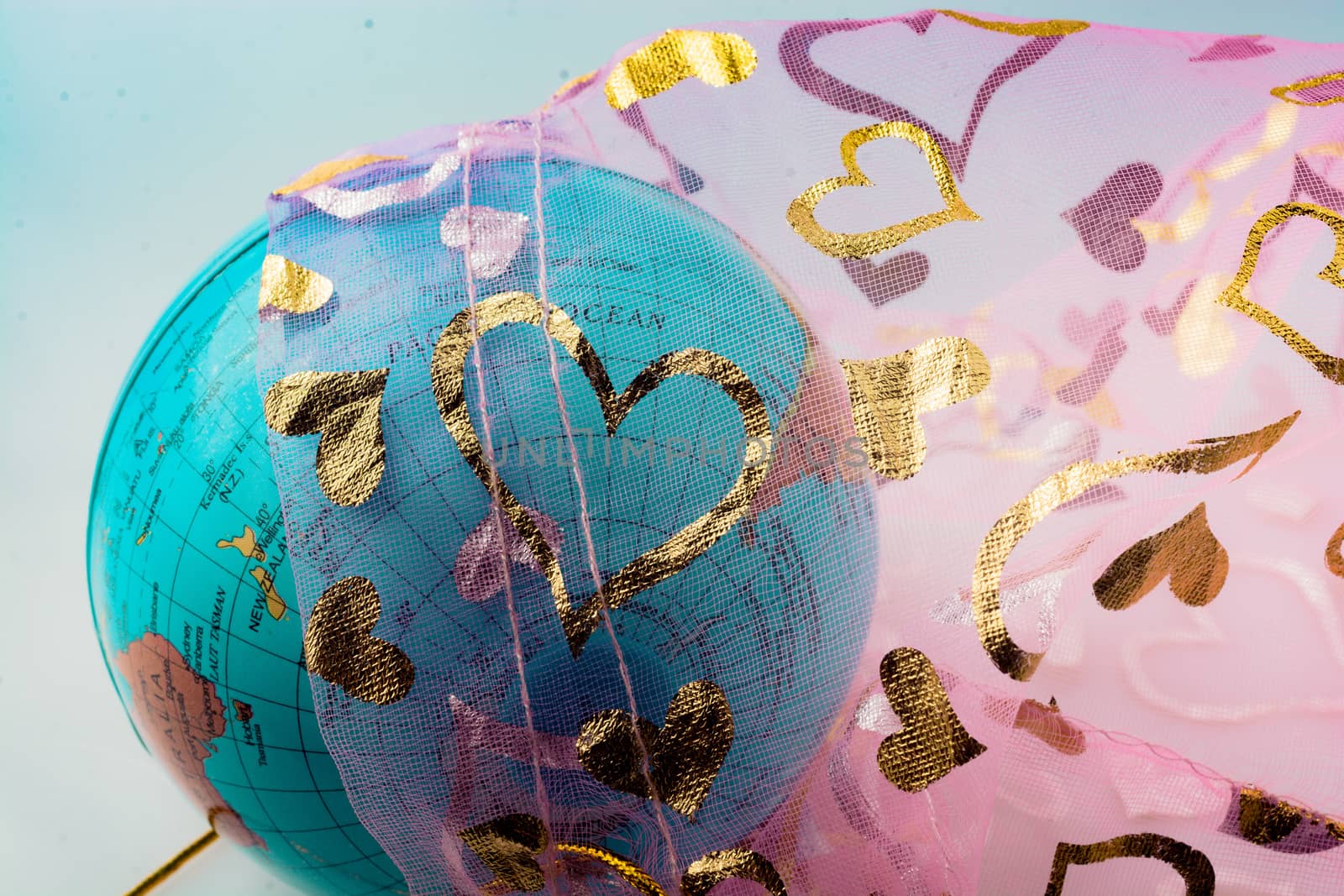 Little model globe under a fabric with heart patterns