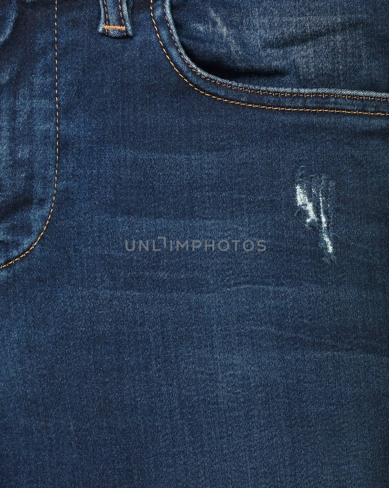 Dark indigo blue washed cotton jeans denim texture background with front pocket, close up