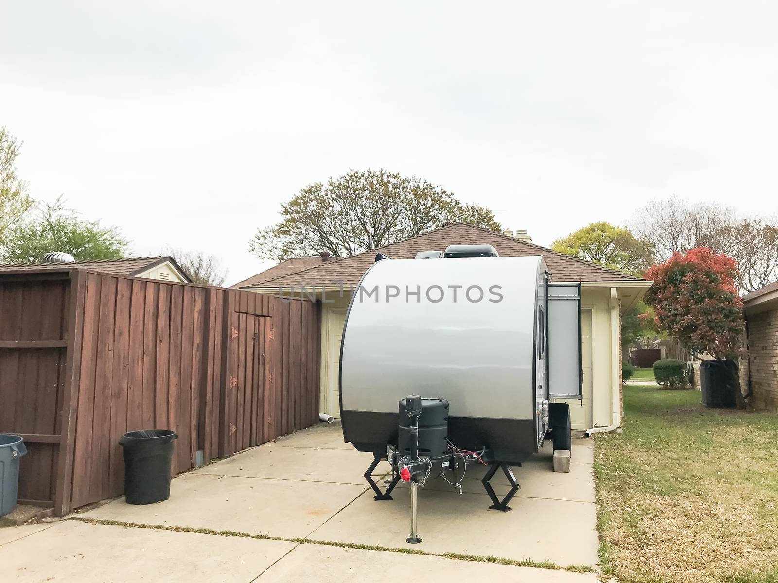 RV trailer parked at backyard of single family house, rear view by trongnguyen