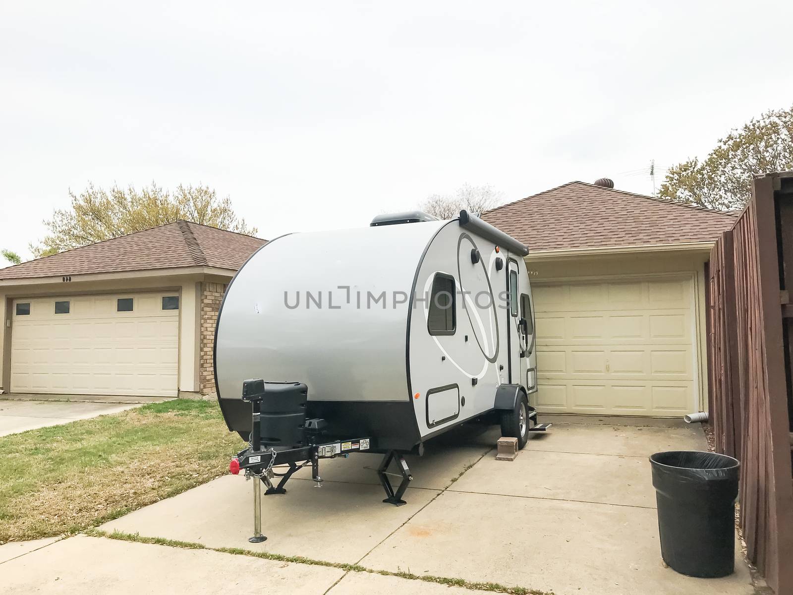 Rear view of RV trailer parked at house garage backyard