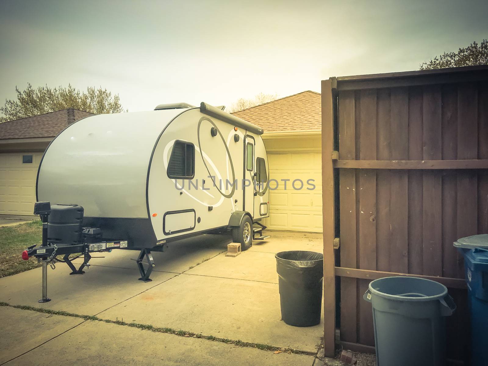 Rear view of RV trailer parked at house garage backyard