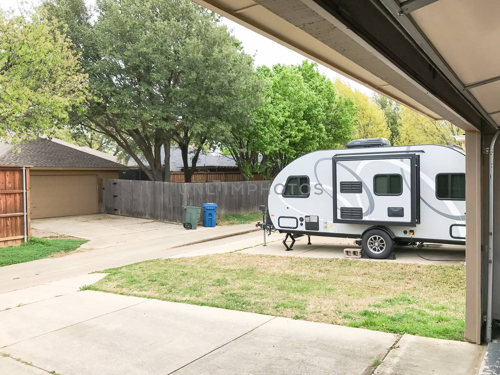 RV trailer parked at backyard, view from inside garage