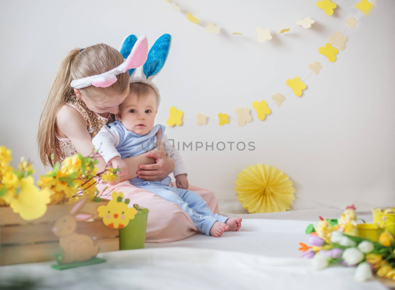 Loving girl and her little brother wearing bunny ears in Easter  by Angel_a