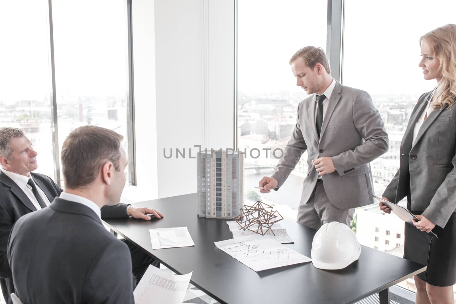 Construction presentation on office , two business people showing model of their project