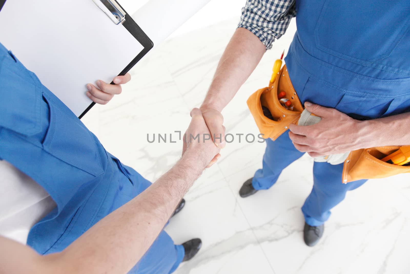 Two construction workers shaking hands, deal is finished concept