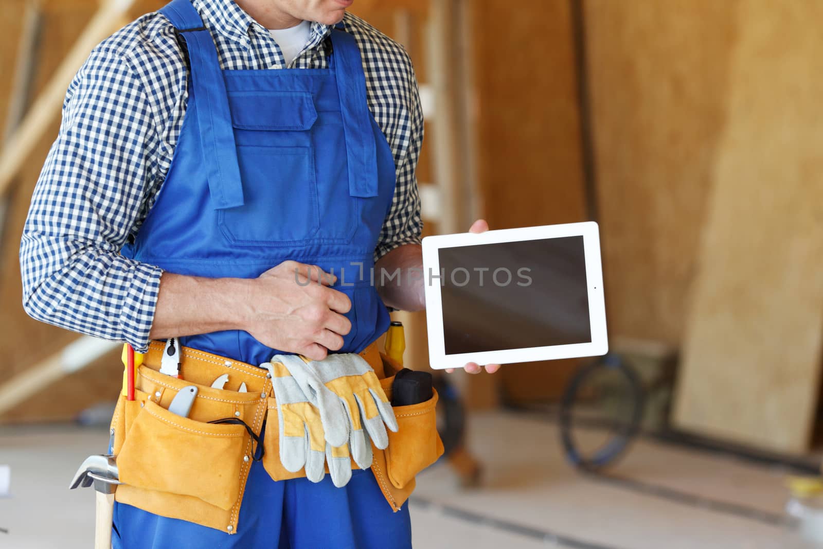 Construction worker pointing at digital tablet at construction site