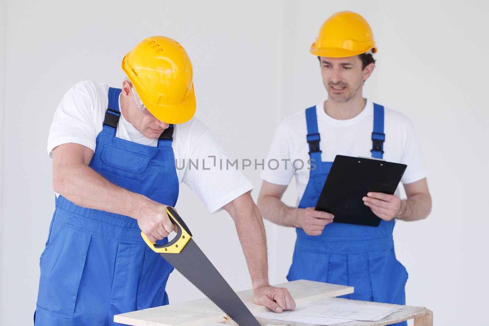 Two workers with hand saw by ALotOfPeople