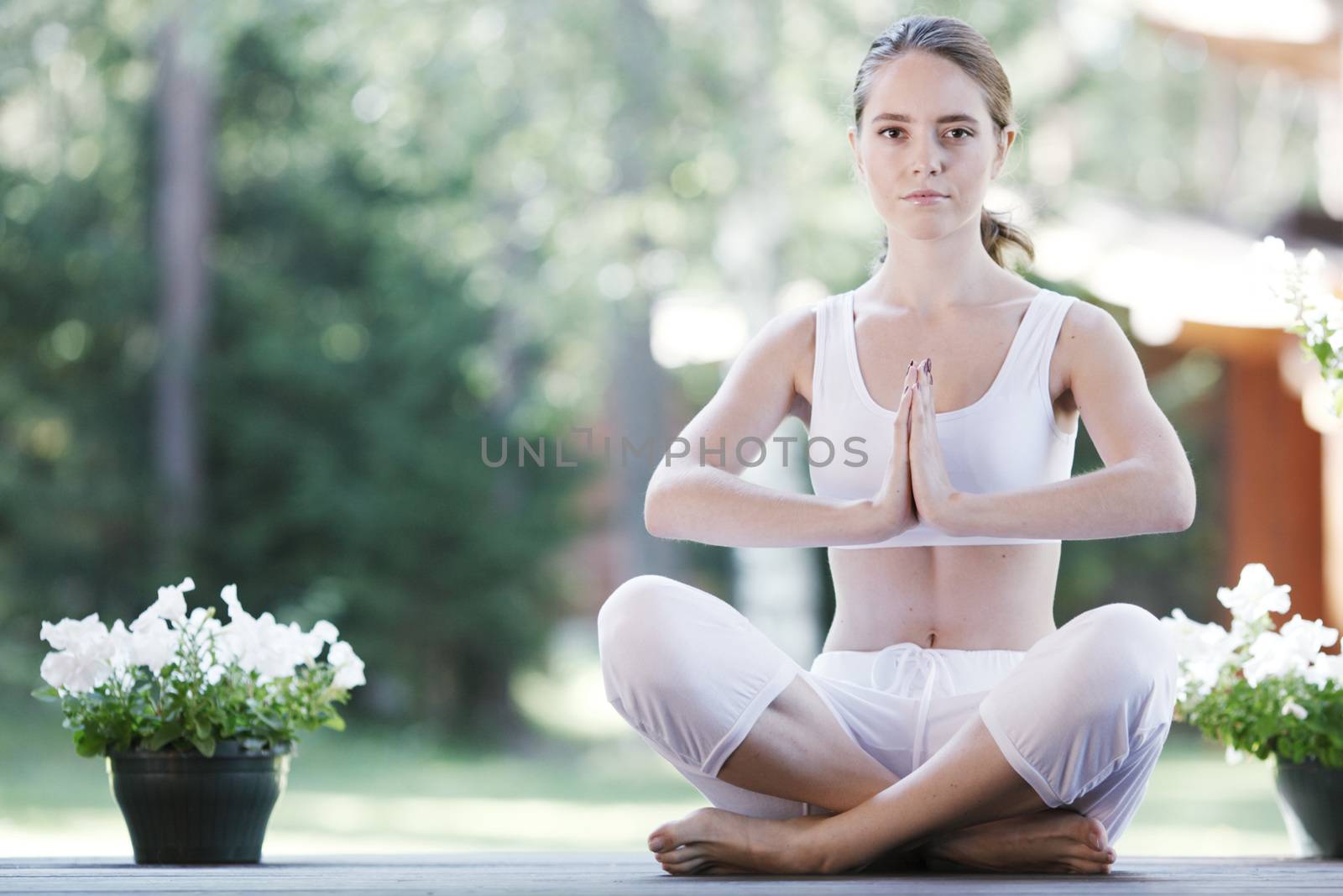 Young woman doing yoga lotus exercise outdoors