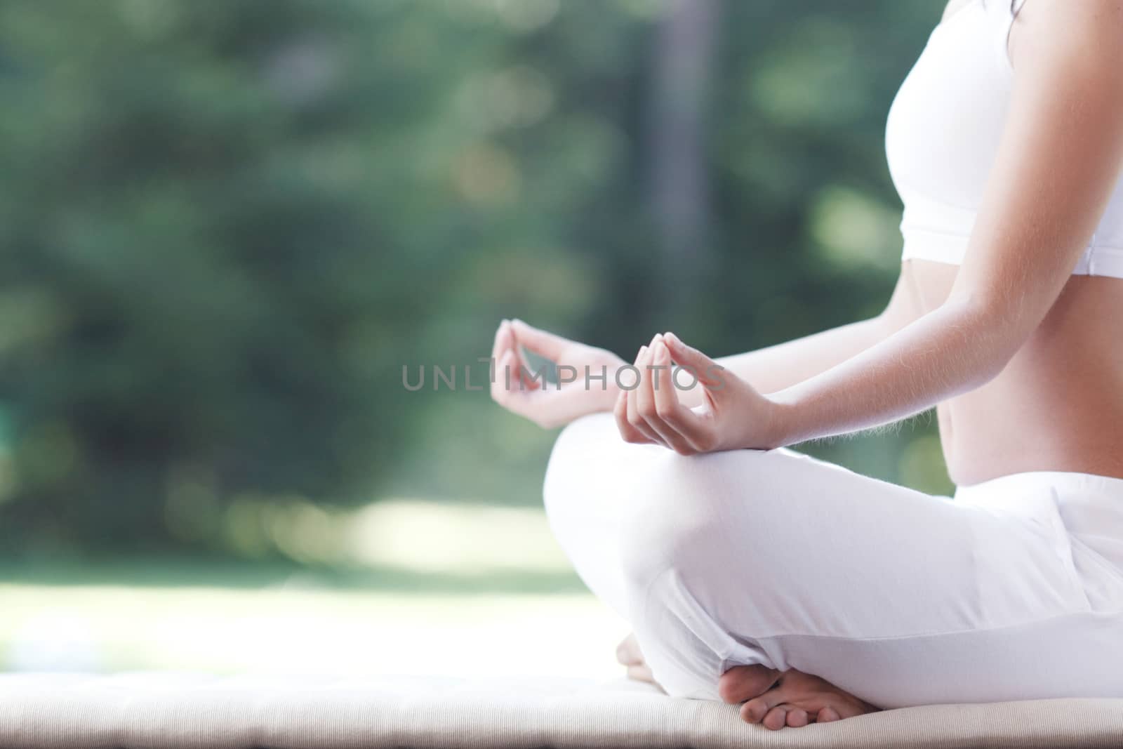 Close-up of young woman doing yoga exercise in the park