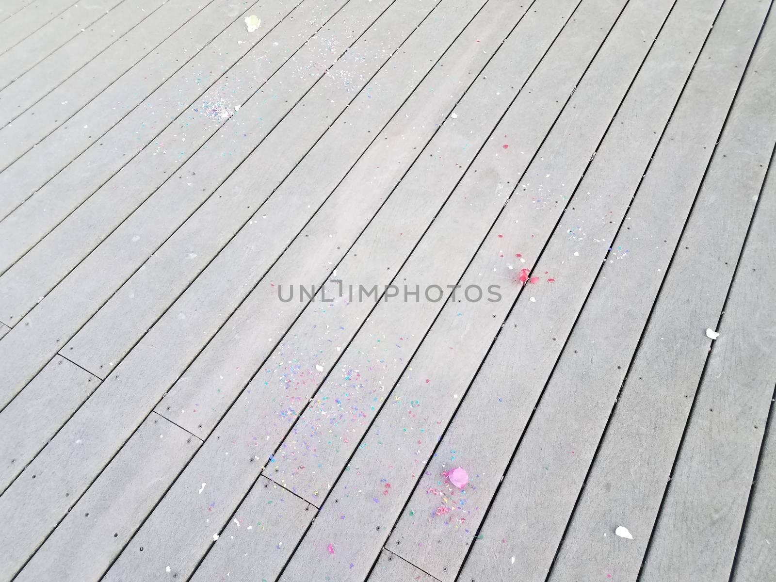 colorful cracked egg shells and paper confetti on wood deck