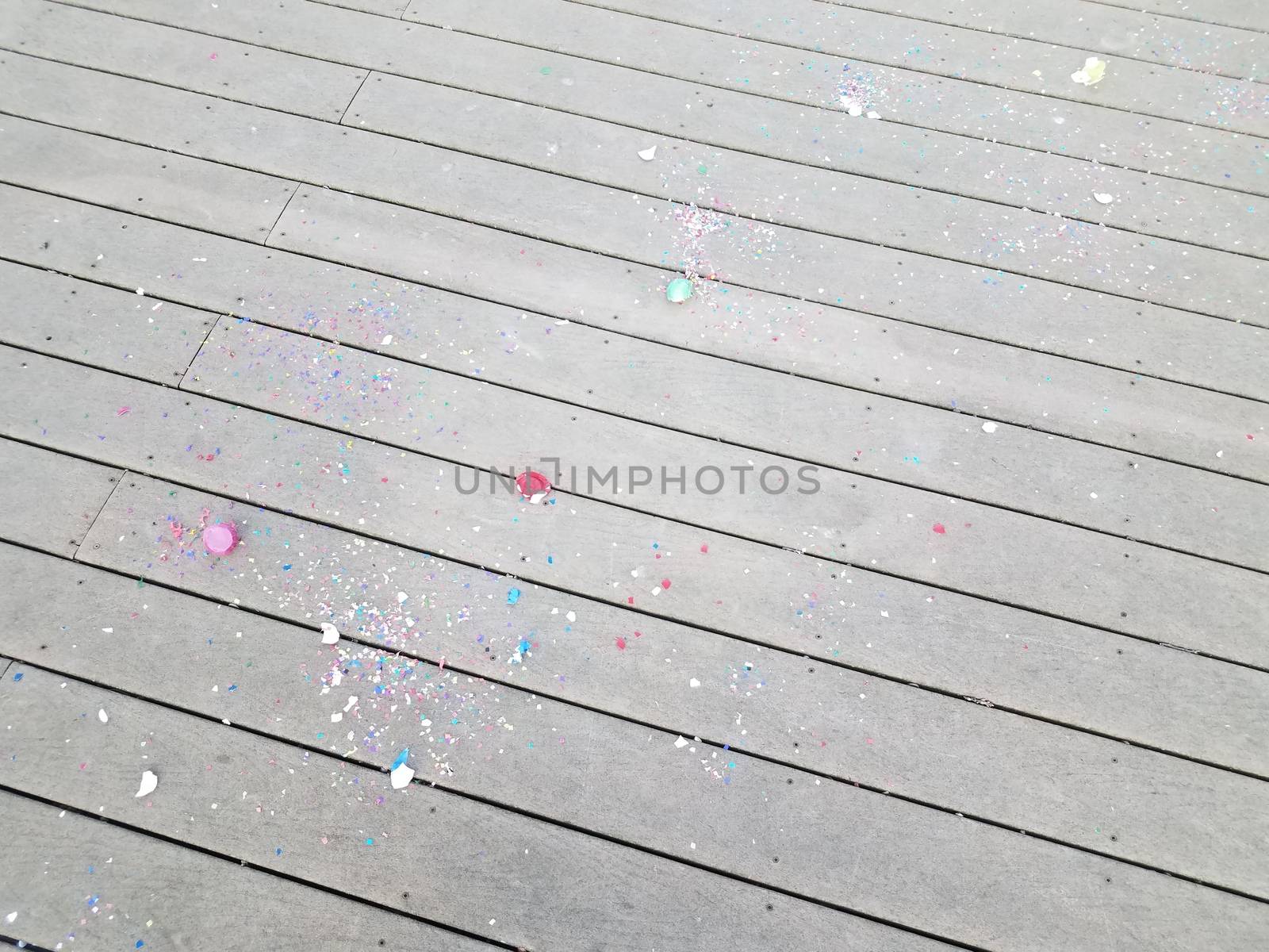 colorful cracked egg shells and paper confetti on wood deck
