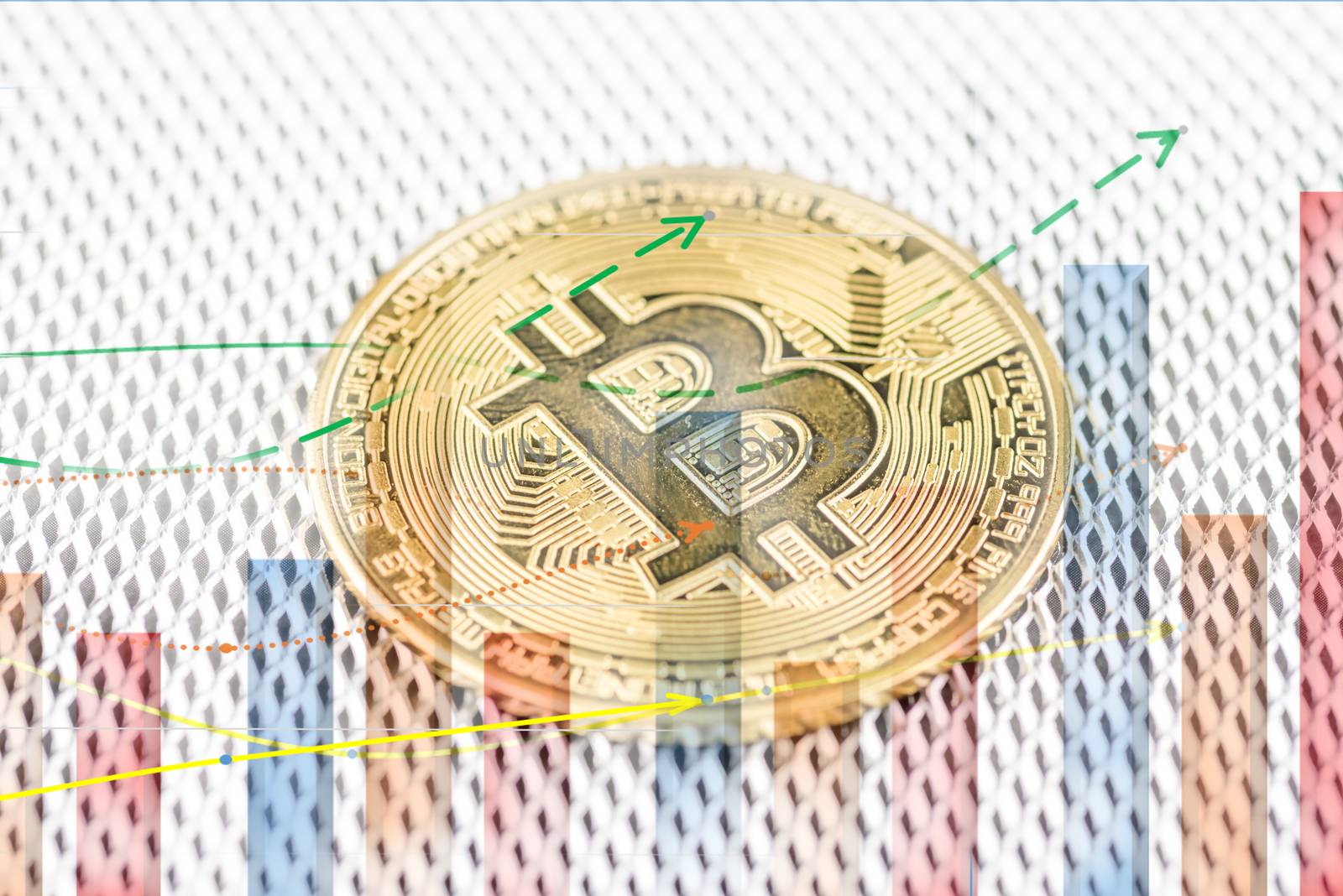 Golden Bitcoin, cryptocurrency physical coin and defocused chart foreground. Virtual cryptocurrency concept
