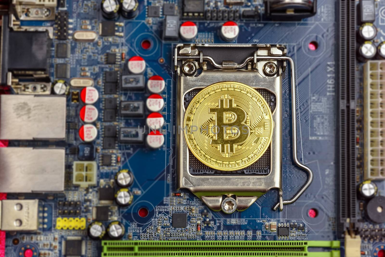 Top view of golden bit coin on computer mother board processor.Bitcoin mining farm, working computer equipment concept.