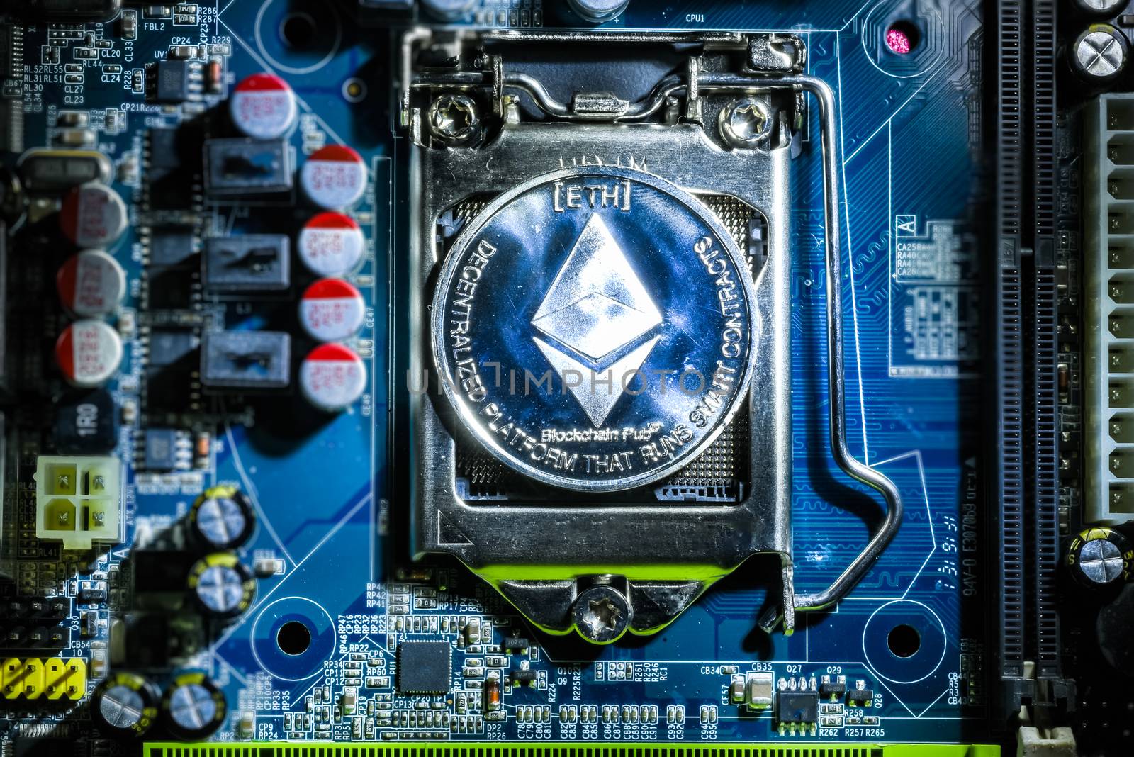 Top view of Silver Ethereum cryptocurrency physical coin on computer mother board processor.Bitcoin mining farm, working computer equipment concept.