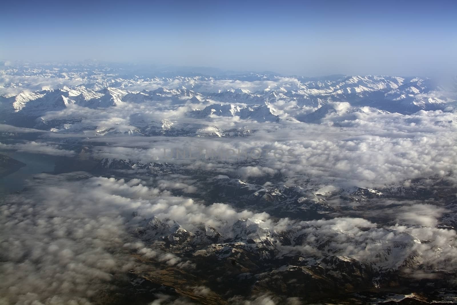 Swiss Alpes with snowy mountain tops aerial view towards the east during afternoon flight in December