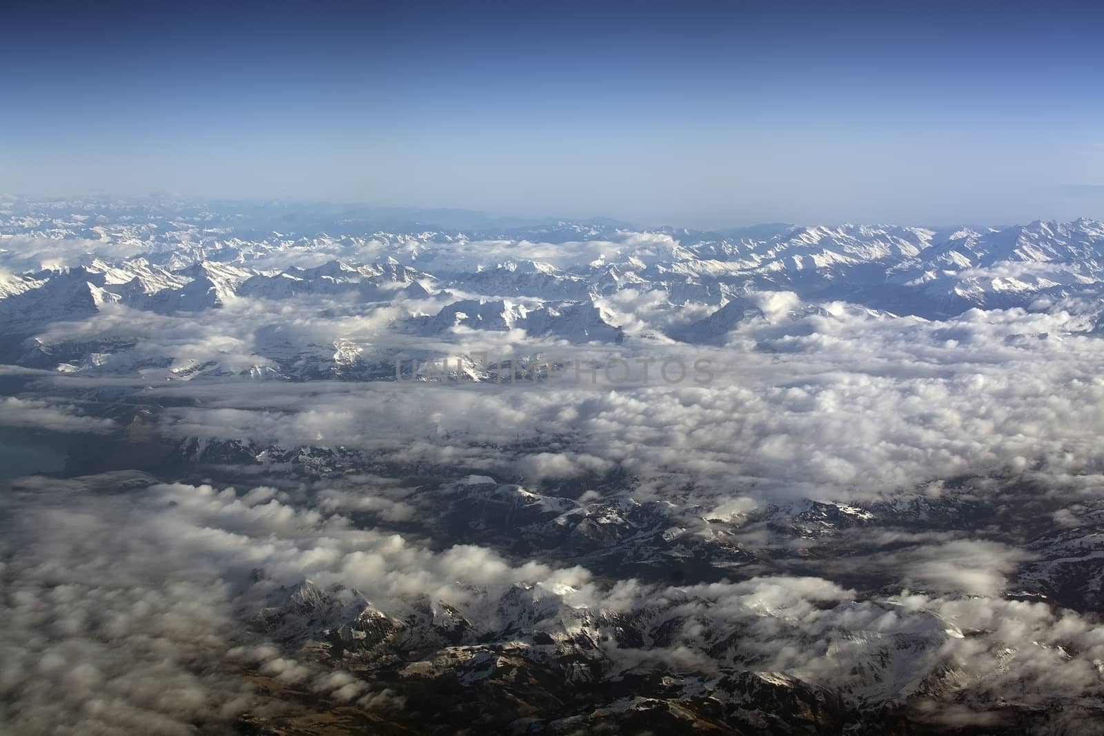 Swiss Alpes with snowy mountain tops aerial view towards the east during afternoon flight in December