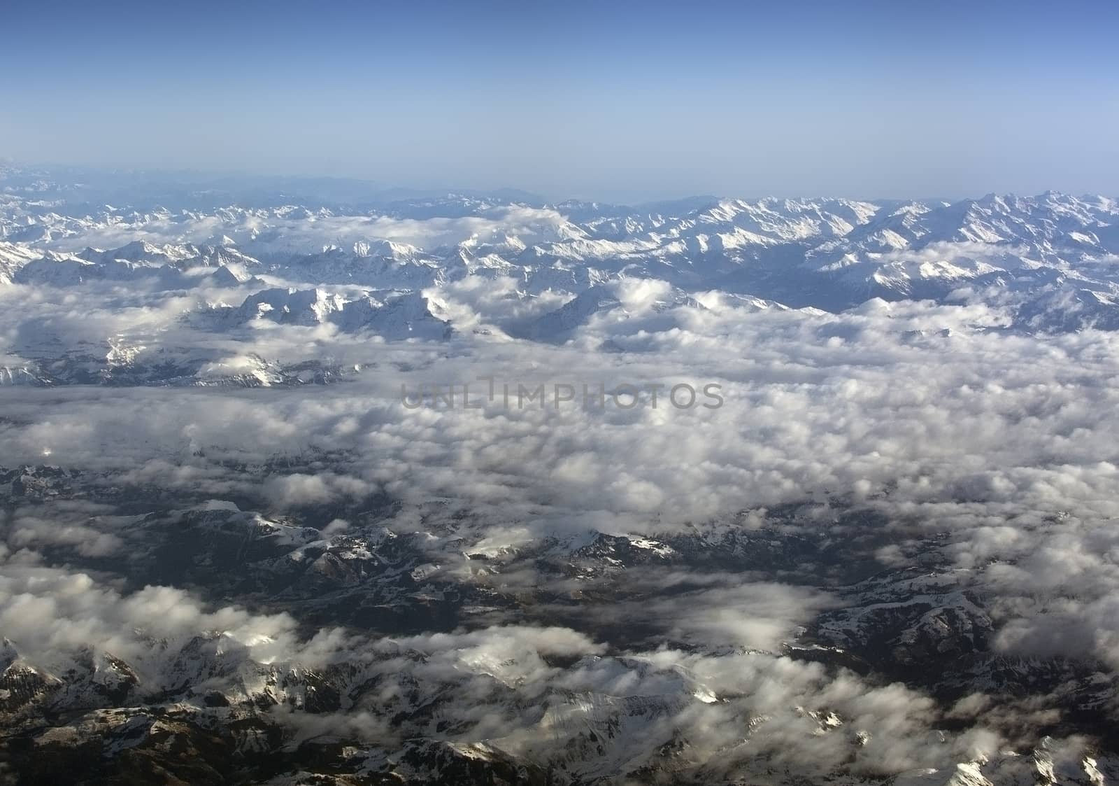 Swiss Alpes with snowy mountain tops aerial view towards the east during afternoon flight in December