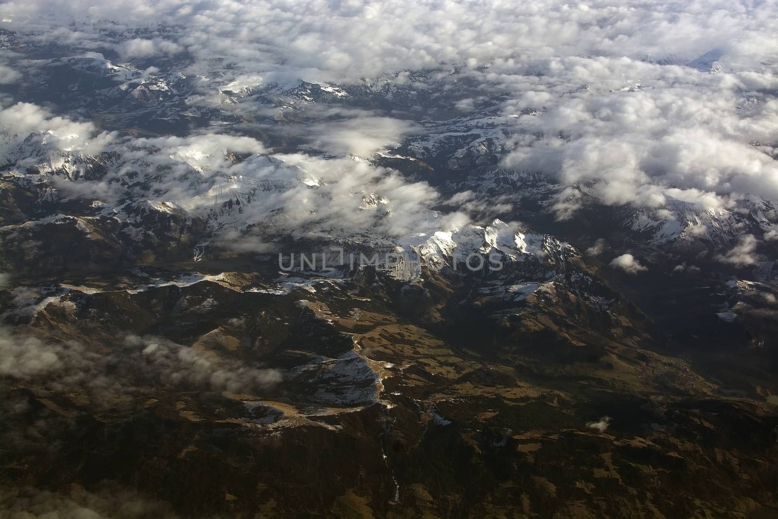 Swiss Alpes with snowy mountain tops aerial view towards the east during afternoon flight in December