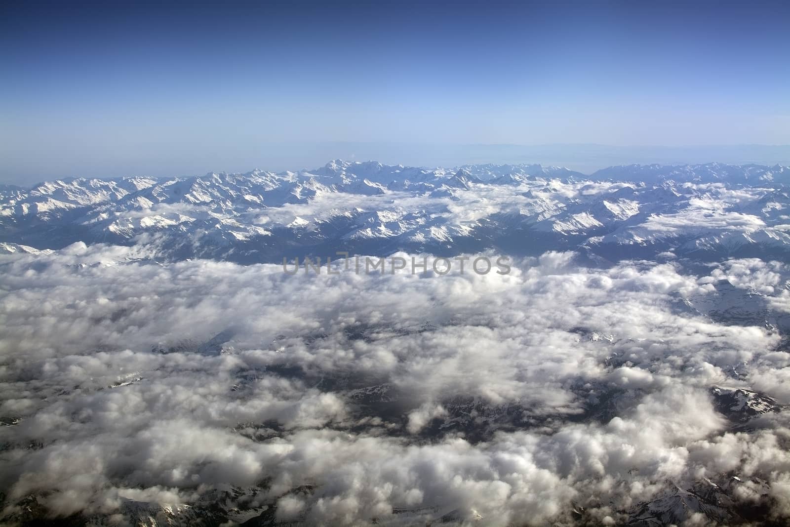 Swiss Alpes with snowy mountain tops aerial view towards the east during afternoon flight in December