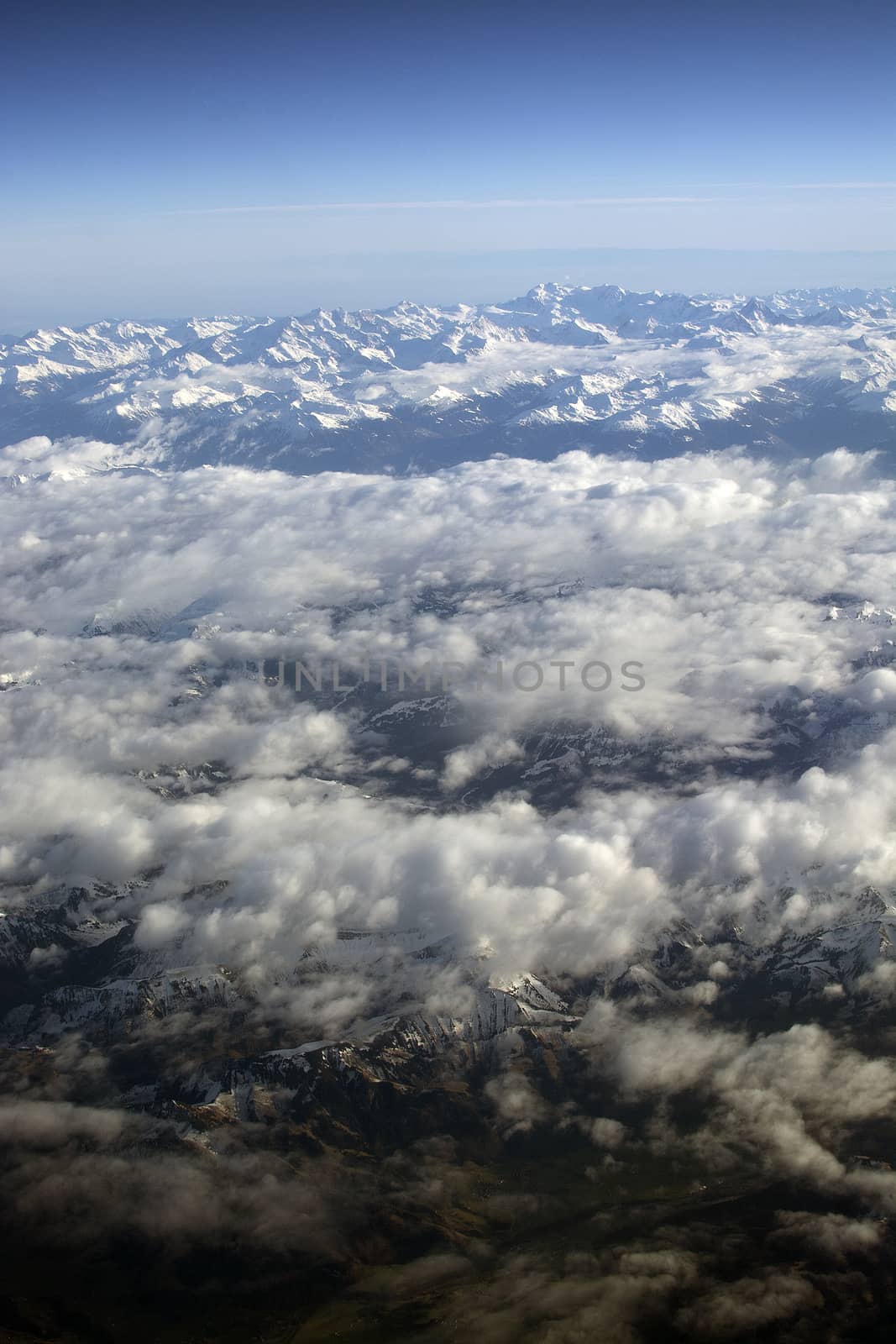 Swiss Alpes with snowy mountain tops aerial view towards the east during afternoon flight in December