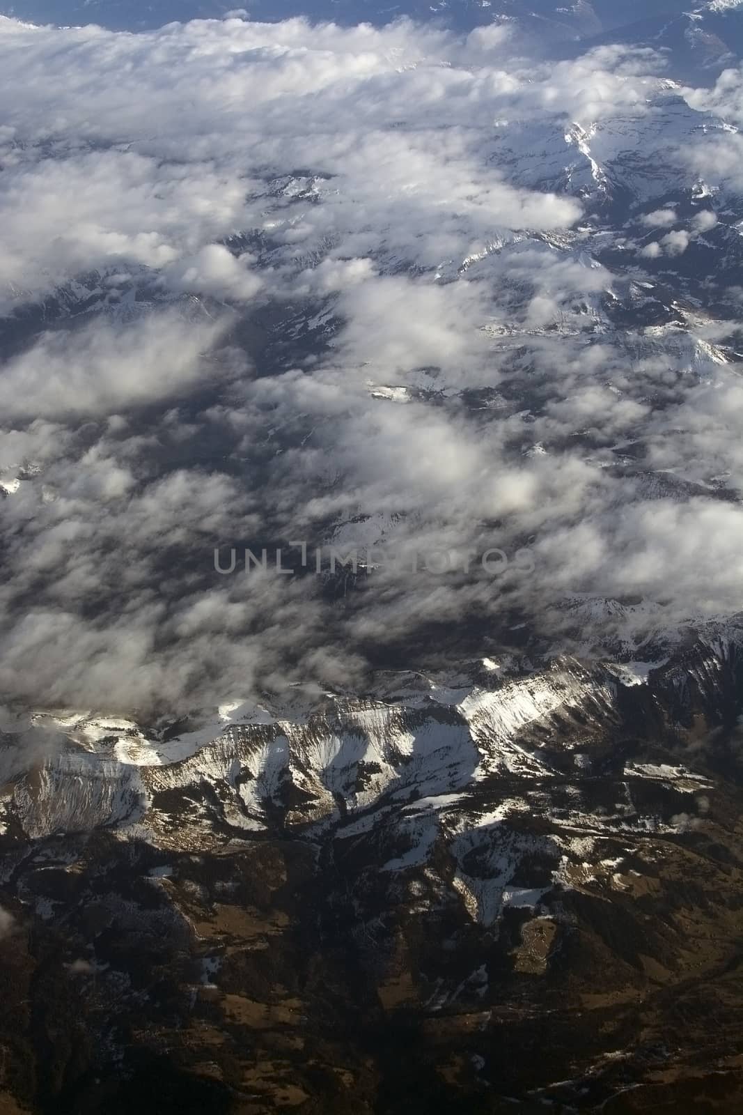 Swiss Alpes with snowy mountain tops aerial view towards the east during afternoon flight in December