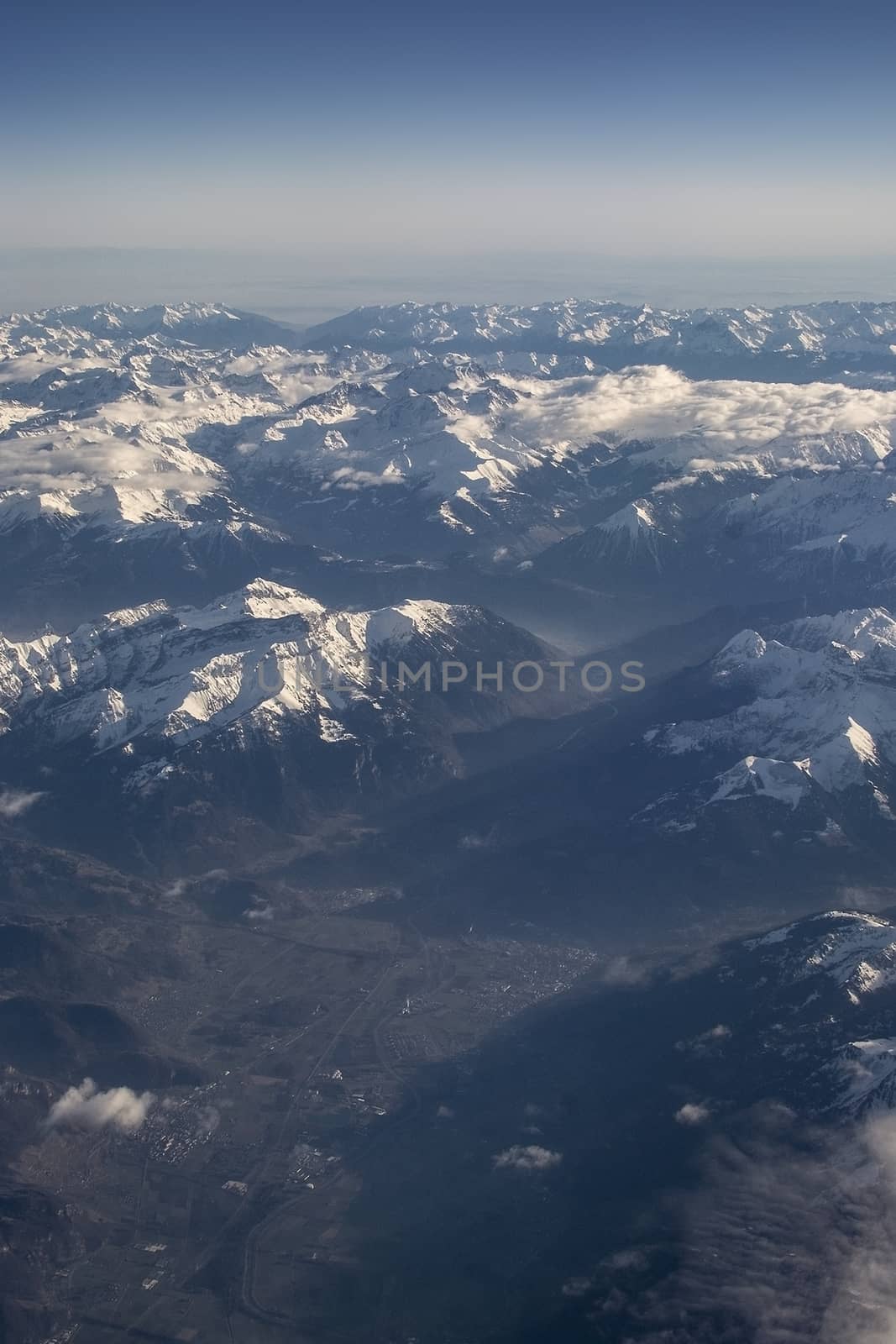 Swiss Alpes with snowy mountain tops aerial view towards the east during afternoon flight in December