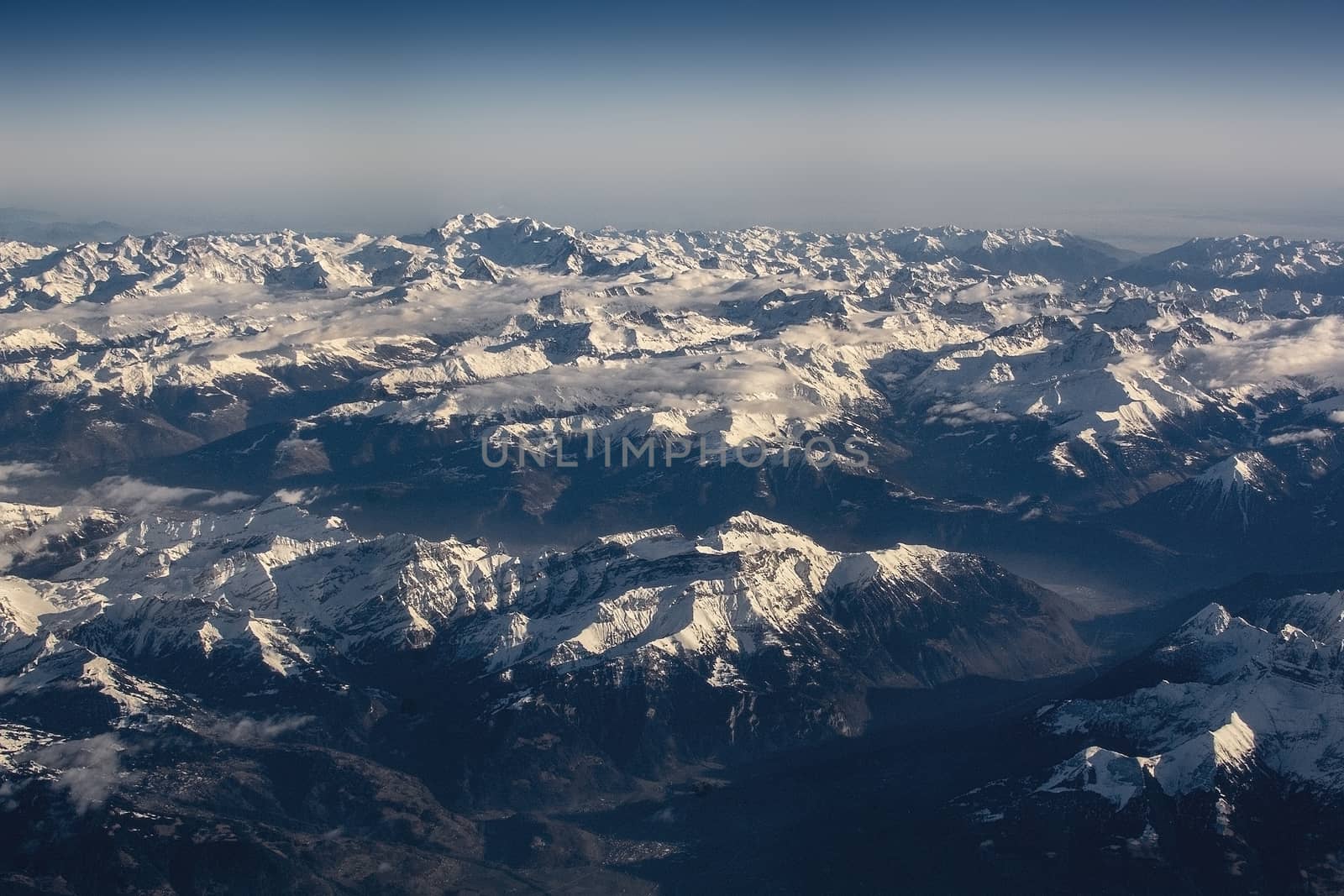 Swiss Alpes with snowy mountain tops aerial view towards the east during afternoon flight in December