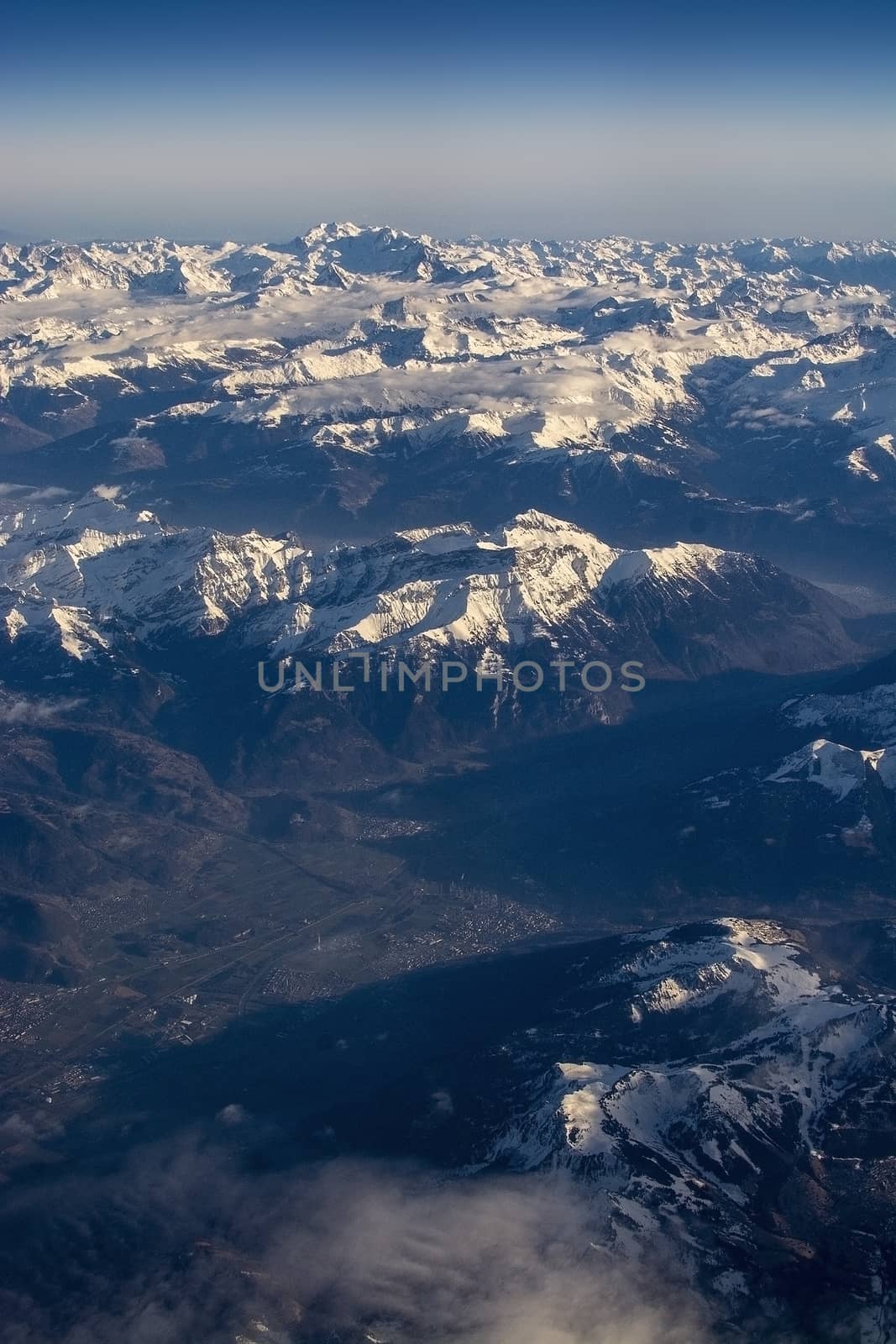 Swiss Alpes with snowy mountain tops aerial view towards the east during afternoon flight in December