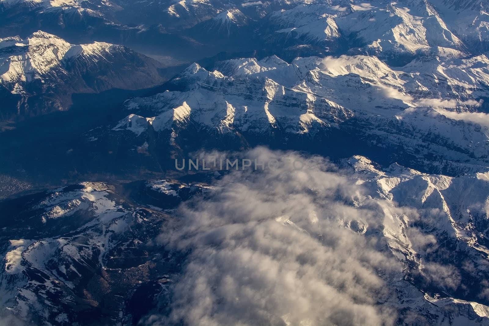 Swiss Alpes with snowy mountain tops aerial view towards the east during afternoon flight in December