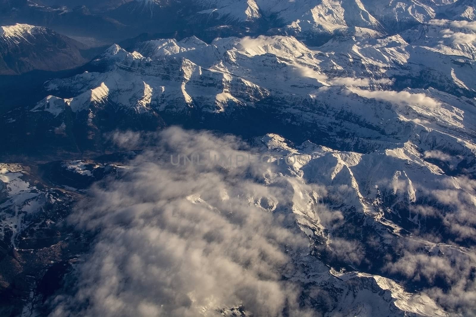 Swiss Alpes with snowy mountain tops aerial view towards the east during afternoon flight in December