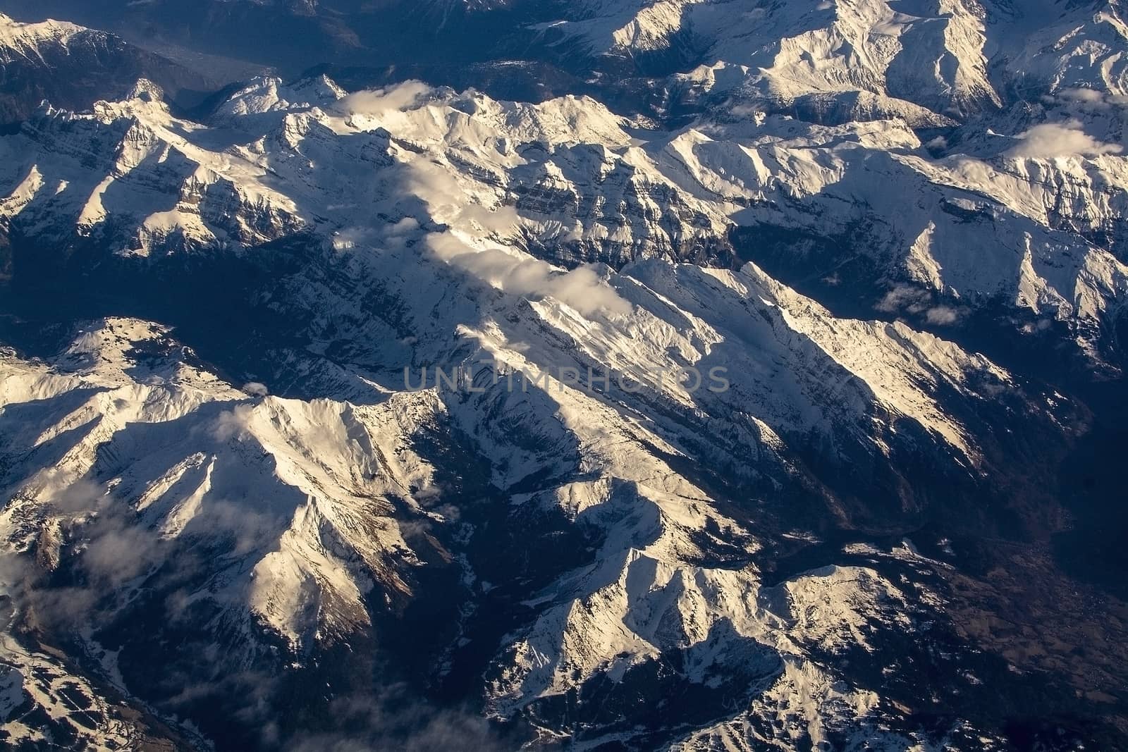 Swiss Alpes with snowy mountain tops aerial view towards the east during afternoon flight in December