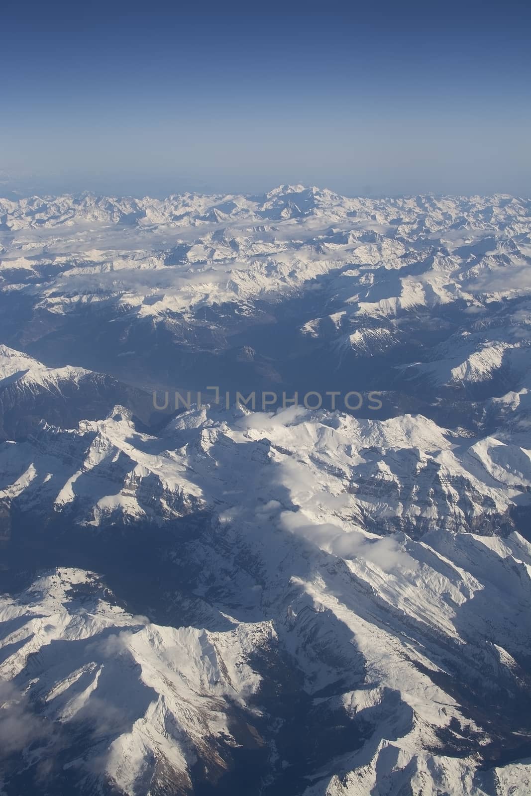 Swiss Alpes with snowy mountain tops aerial view towards the east during afternoon flight in December