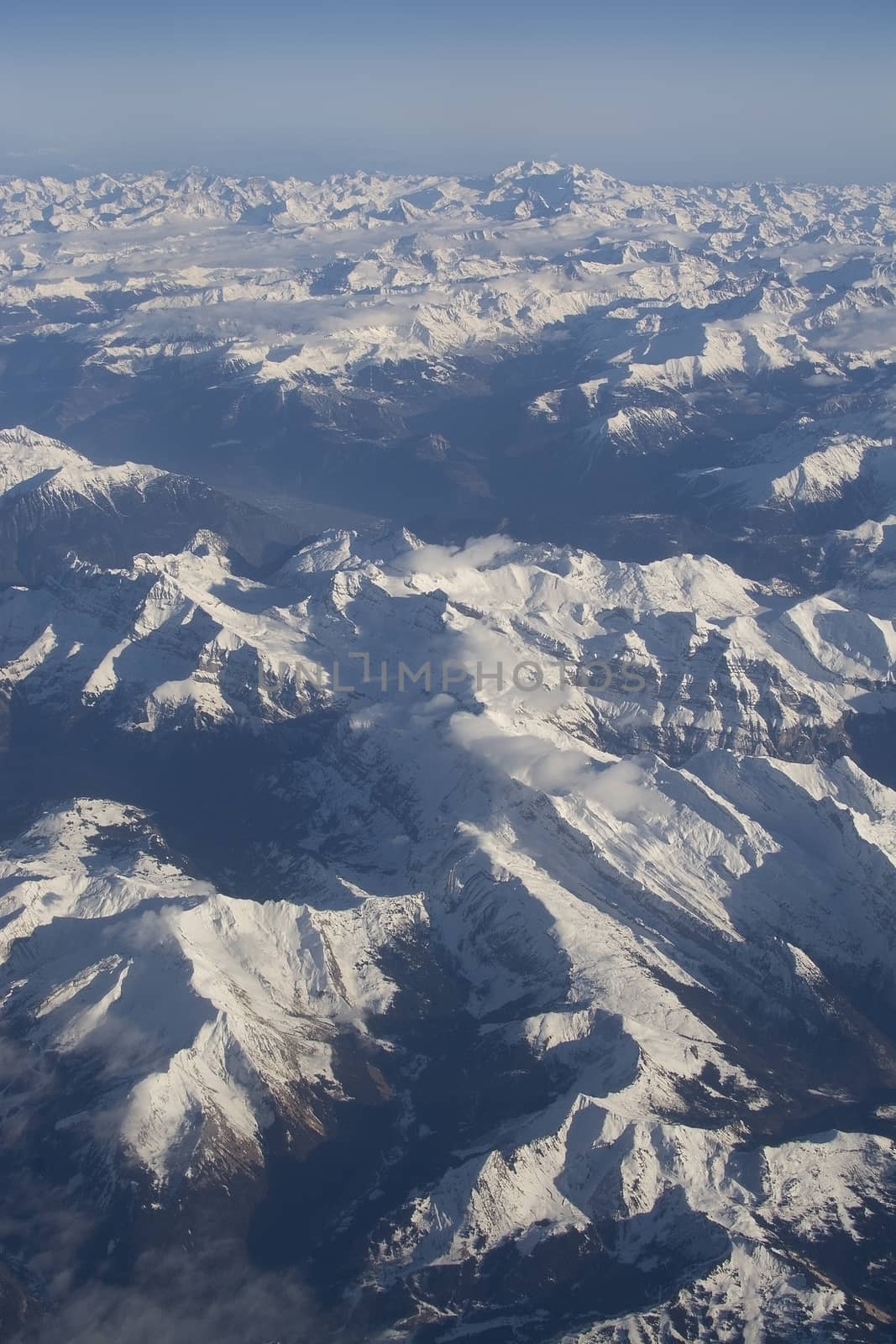 Swiss Alpes with snowy mountain tops aerial view towards the east during afternoon flight in December