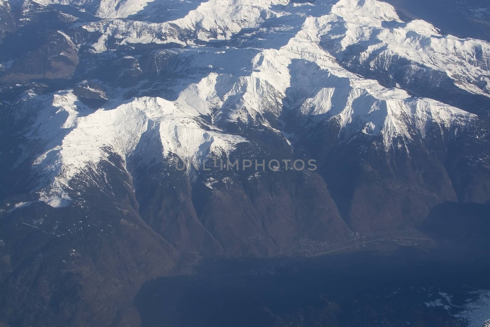 Swiss Alpes with snowy mountain tops aerial view towards the east during afternoon flight in December