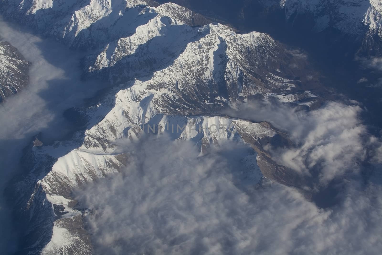 Swiss Alpes with snowy mountain tops aerial view towards the east during afternoon flight in December