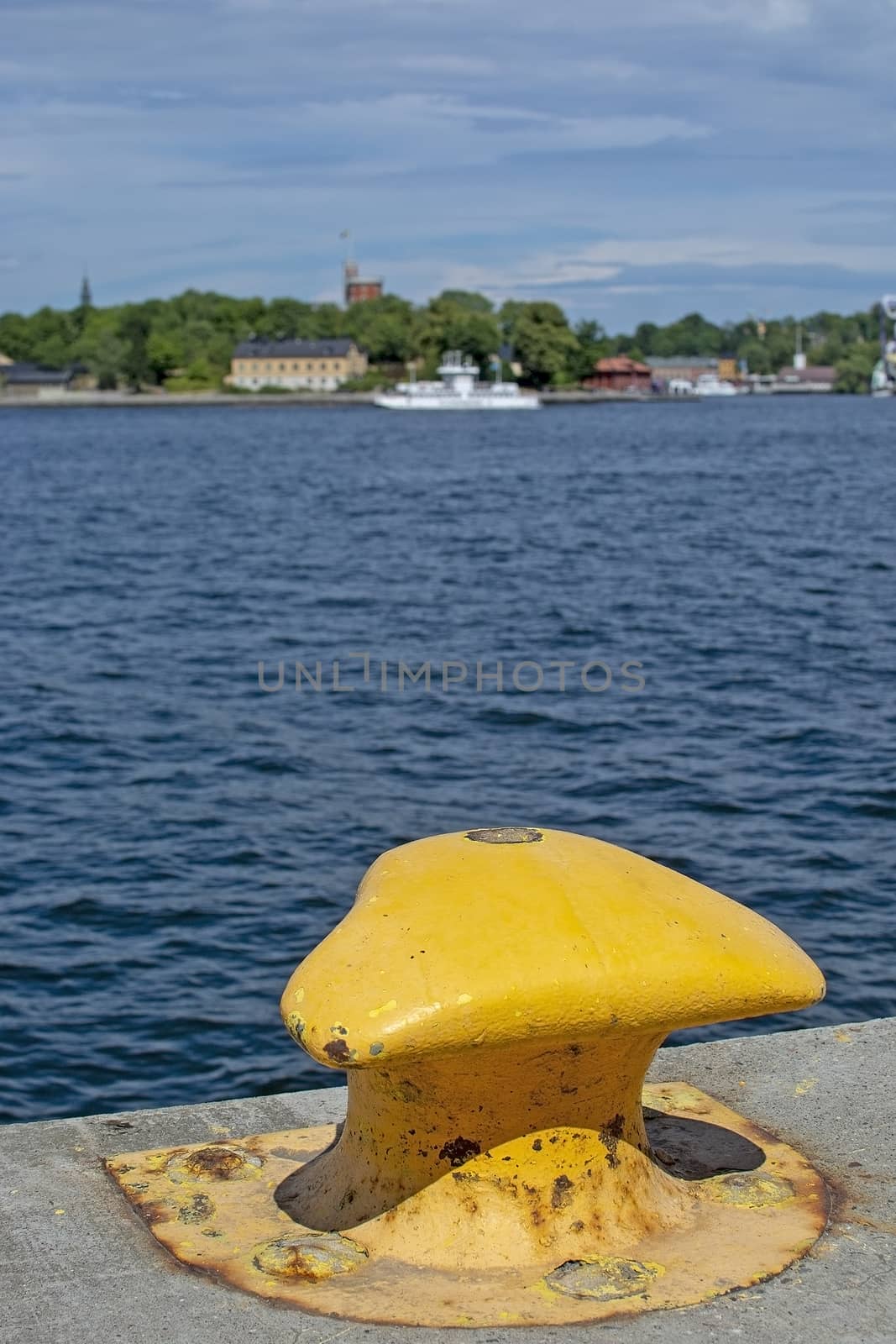 View to Kastellholmen with yellow mooring knob at Stadsgardskajen in July in Stockholm, Sweden.