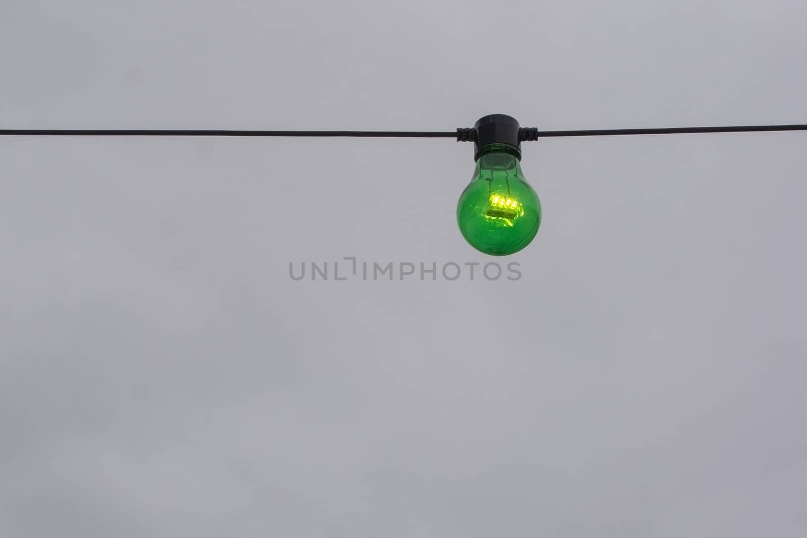 Green color lightbulb on string  by ArtesiaWells