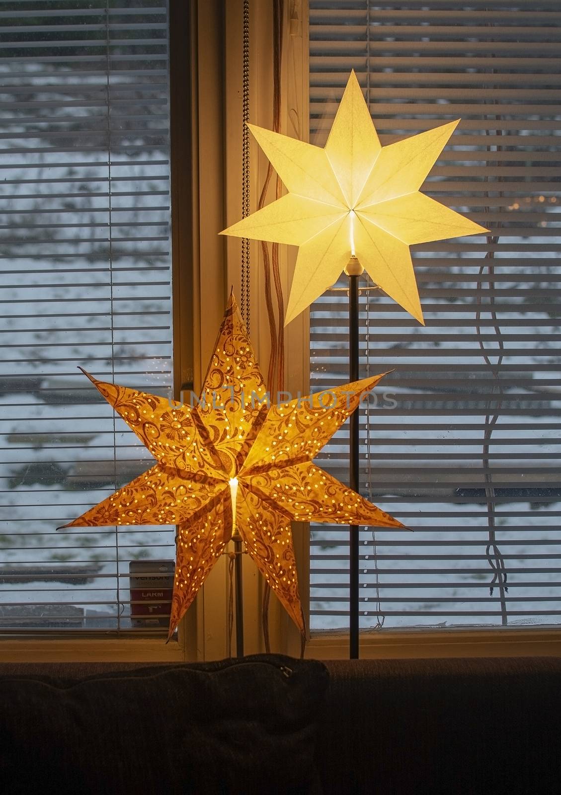 Advent star christmas decorations in window with snow outside in the afternoon in Stockholm, Sweden.