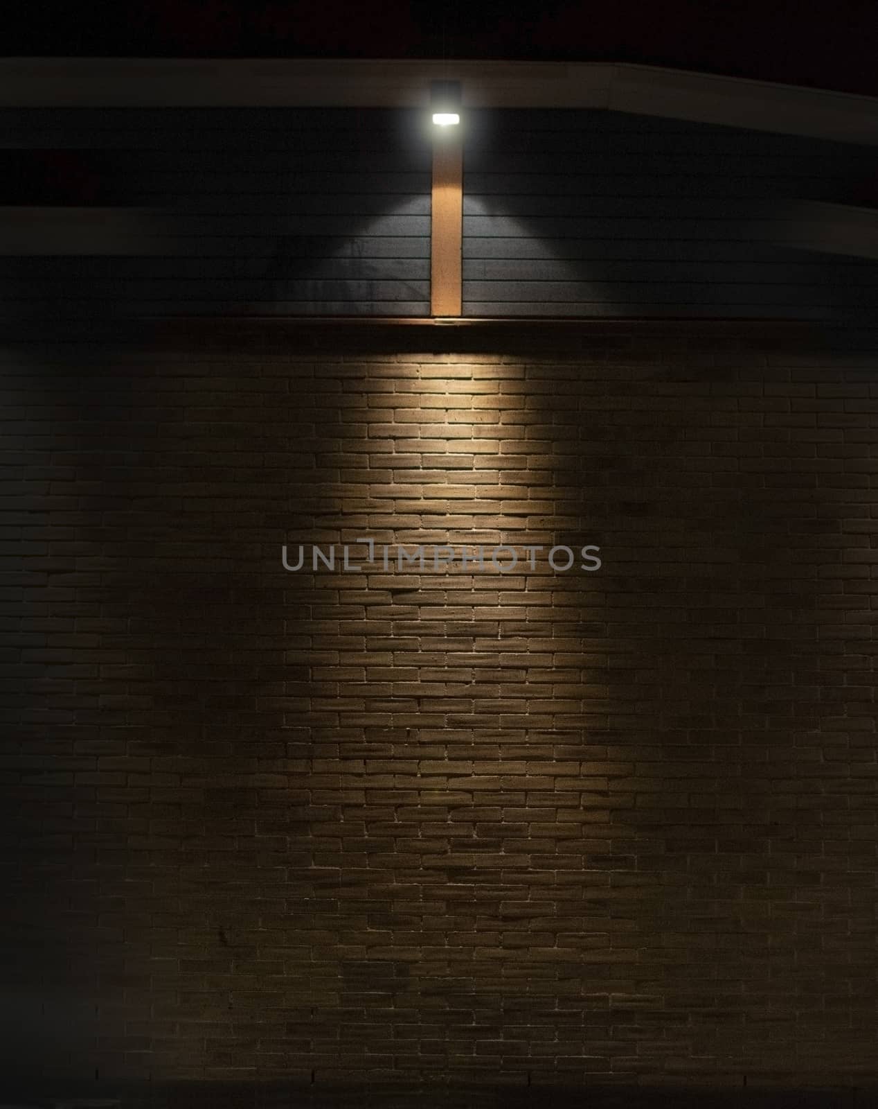 Brick and wood wall background in darkness with lights in triangular shape