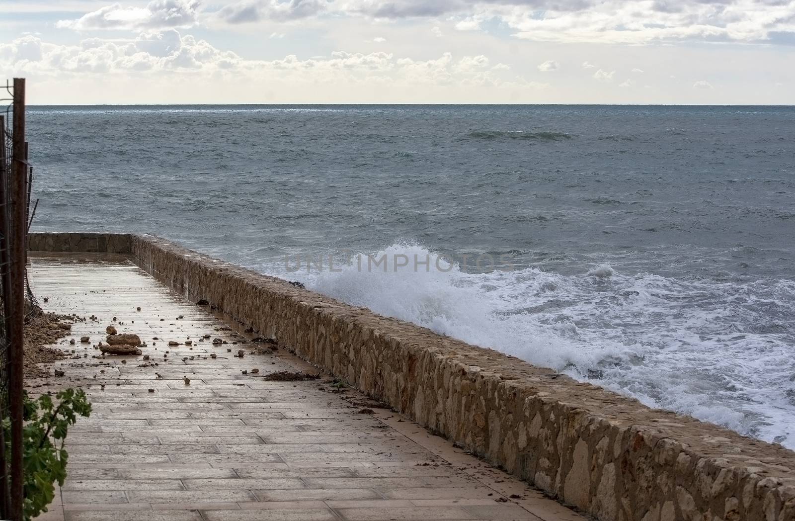 Sea water breaks against rocks and inundates promenade on a stormy winter day in Mallorca, Spain.