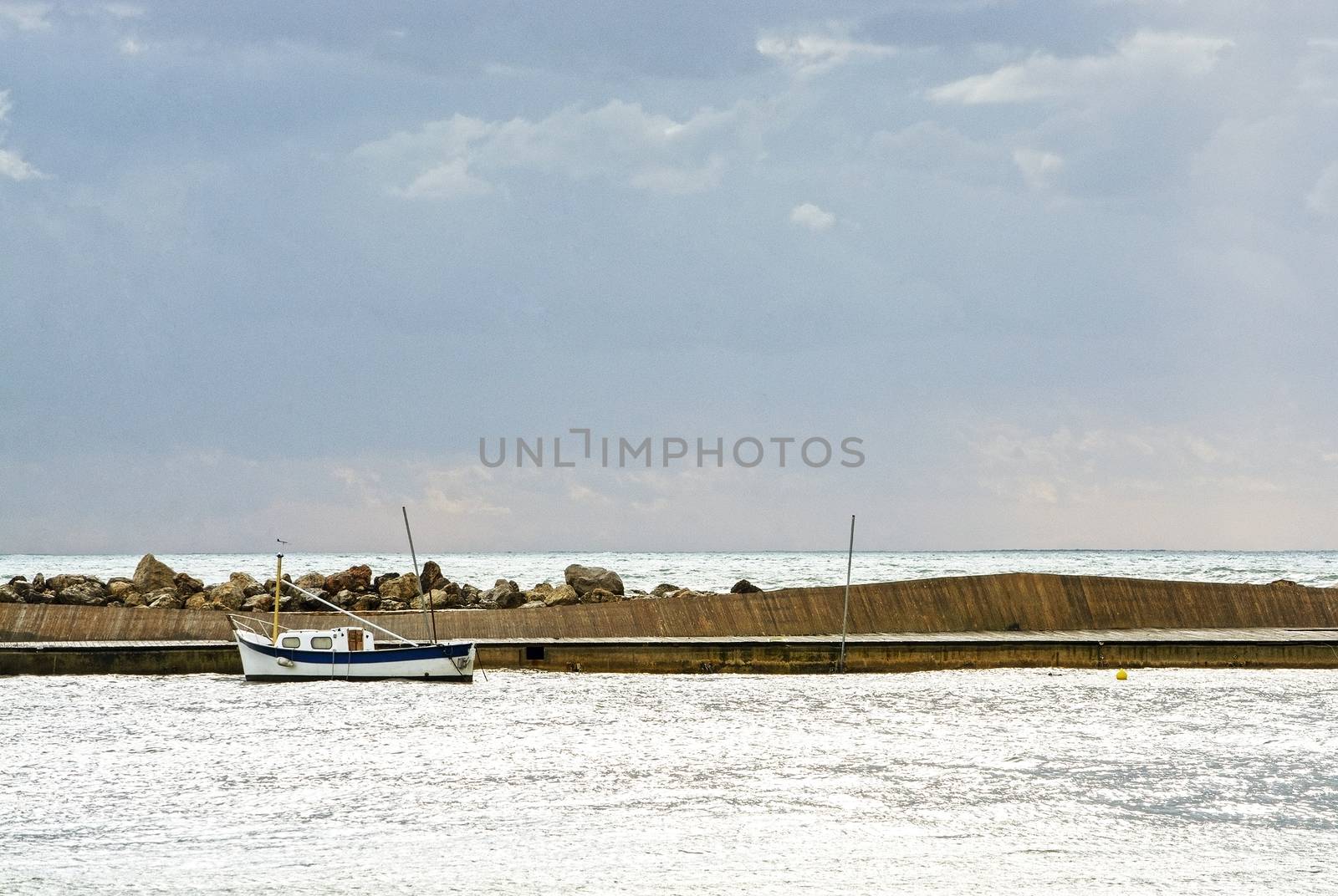 Mediterranean sea view with pier against dark skies with dramatic light