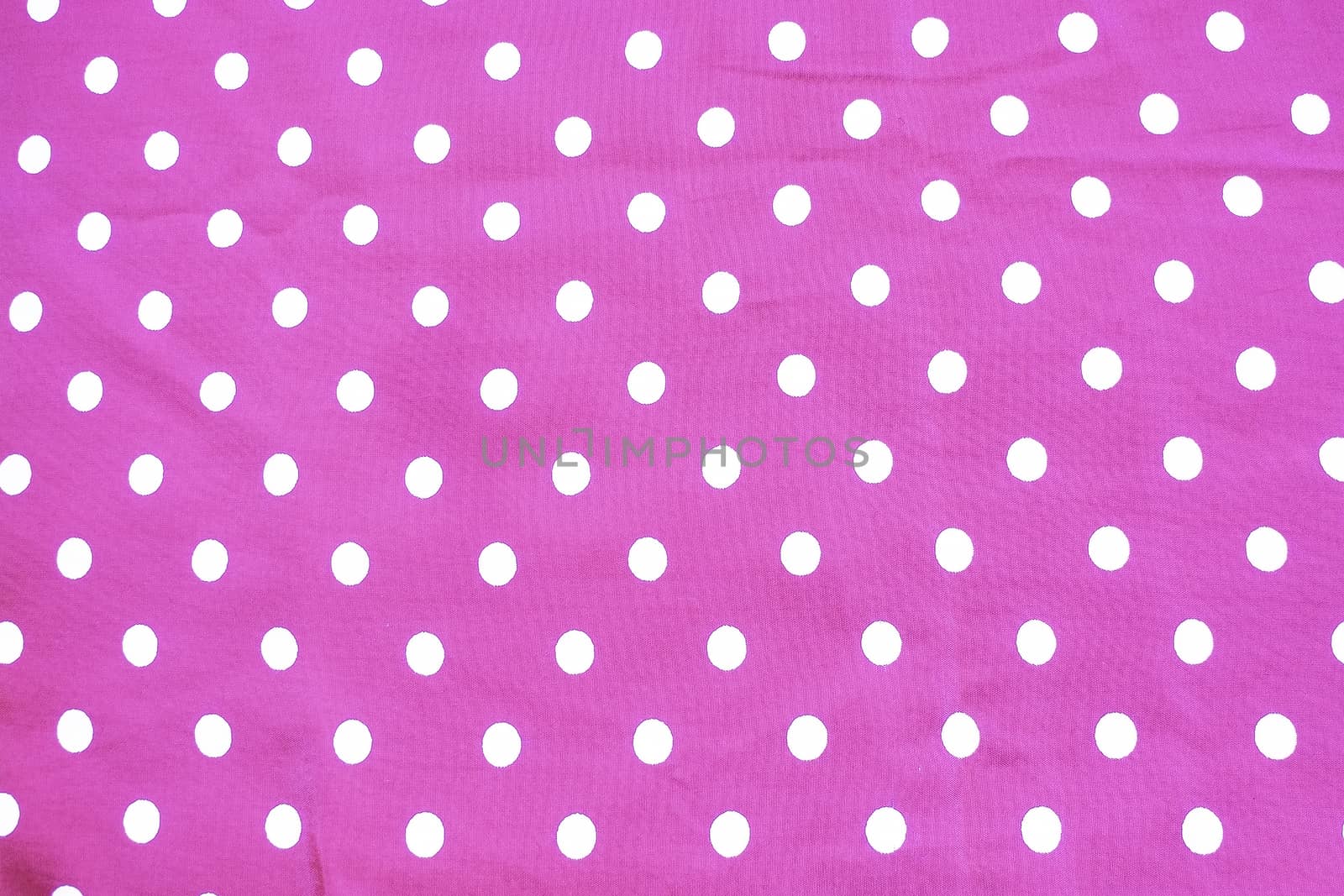 Pink and white polka dot printed fabric fun romantic background texture.