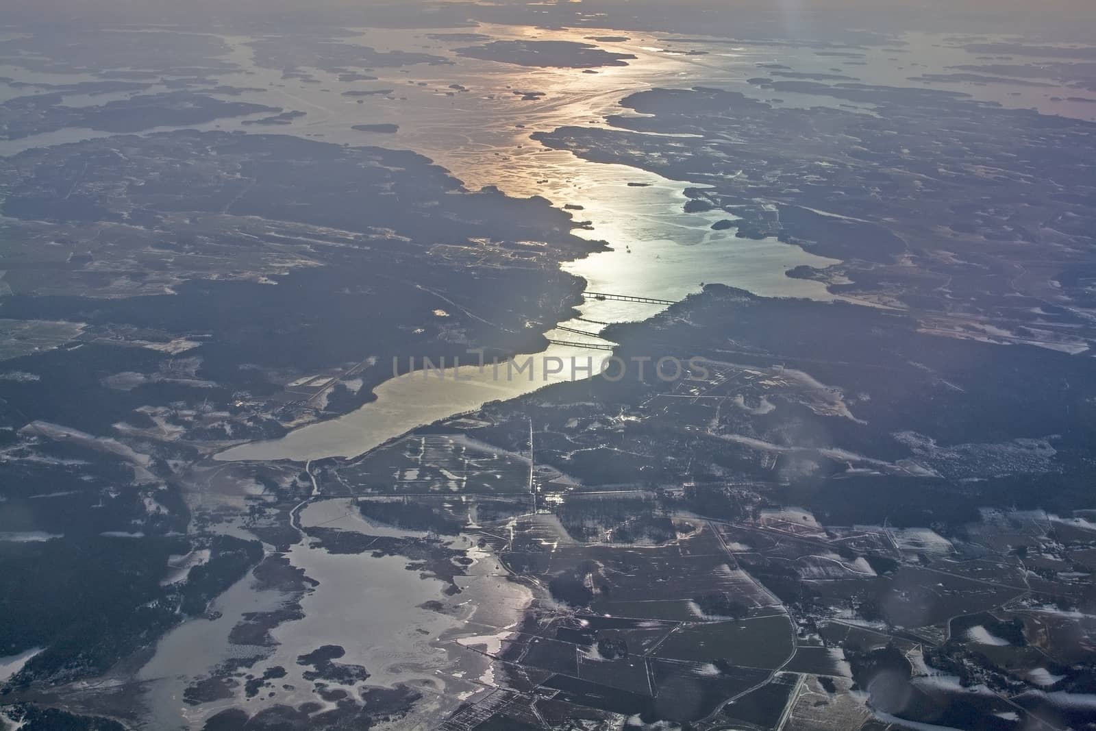 Aerial landscape with golden light over water and forest in Sweden