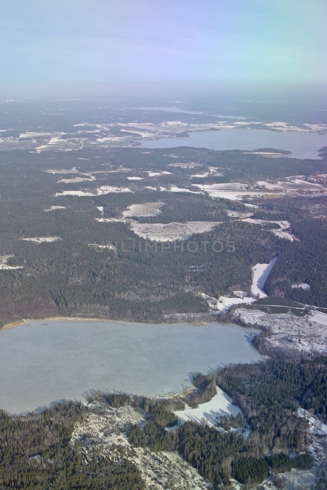 Aerial landscape snowy winter view of farmland on a sunny day in Stockholm, Sweden.