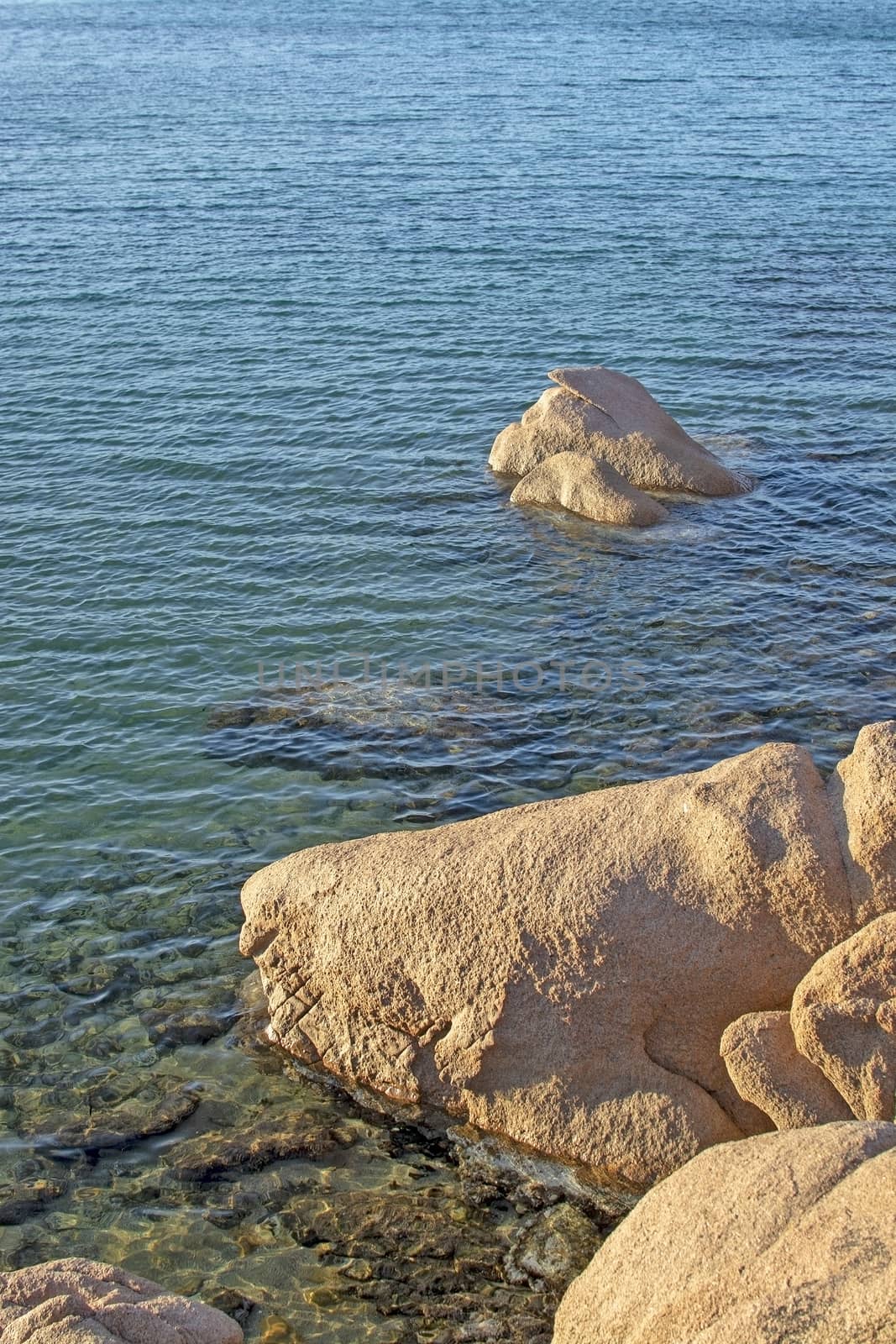 Green water and funny granite rock shapes on a beach in Costa Smeralda, Sardinia, Italy in March.