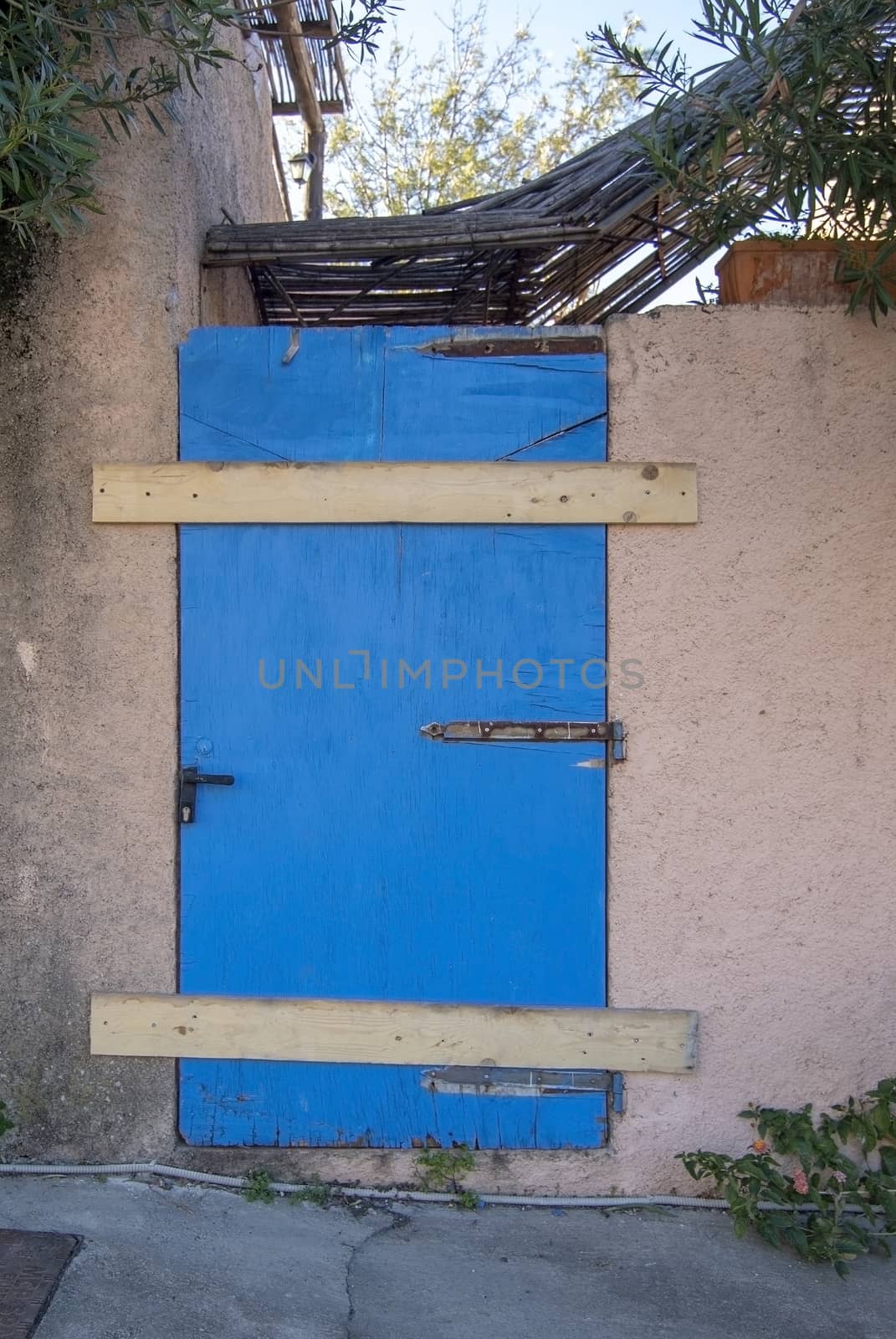 Old wooden weathered door painted blue closed with wood panels unavailable closed concept