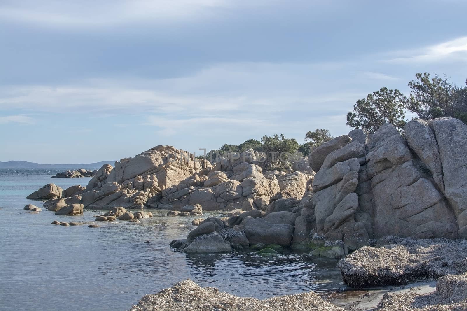 Green water and funny granite rock shapes on a beach in Costa Smeralda, Sardinia, Italy in March.