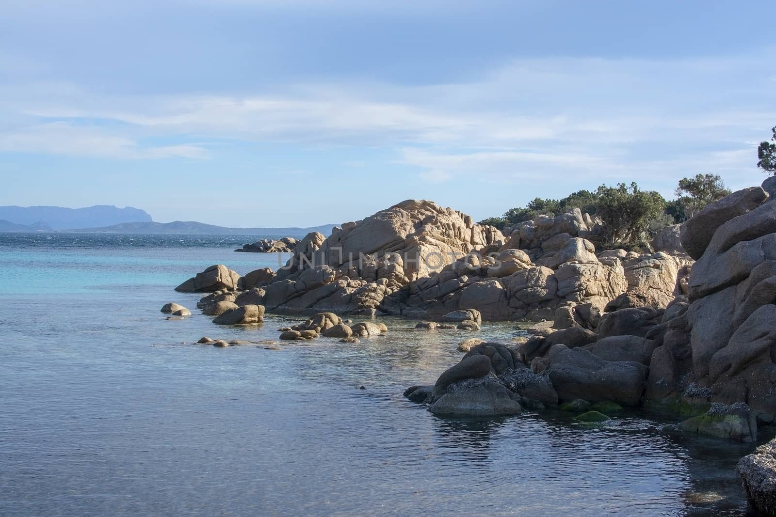 Green water and funny granite rock shapes on a beach in Costa Smeralda, Sardinia, Italy in March.