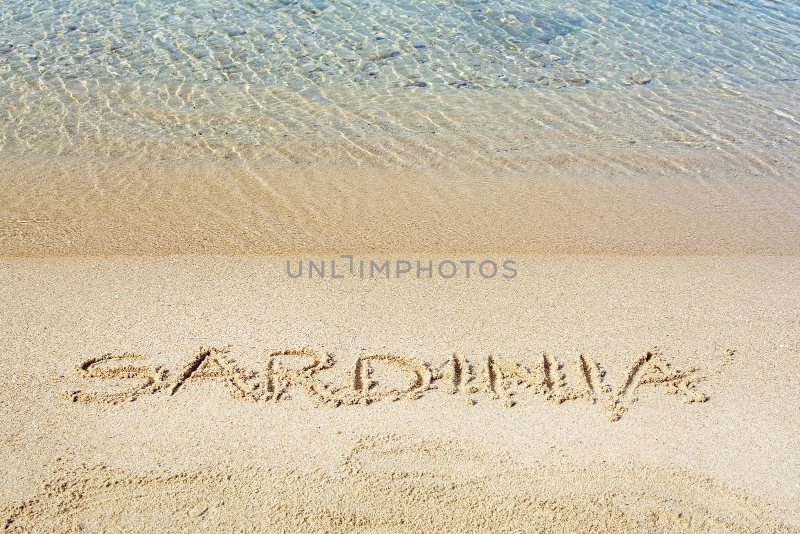 Sardinia word written in sand on a beach in Costa Smeralda, Sardinia, Italy.